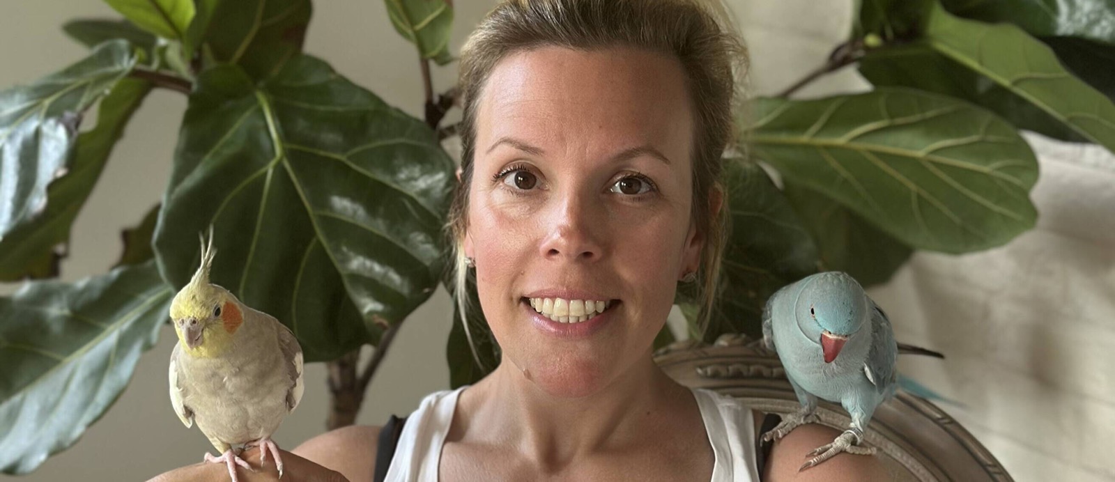 Sara with two birds in a home setting